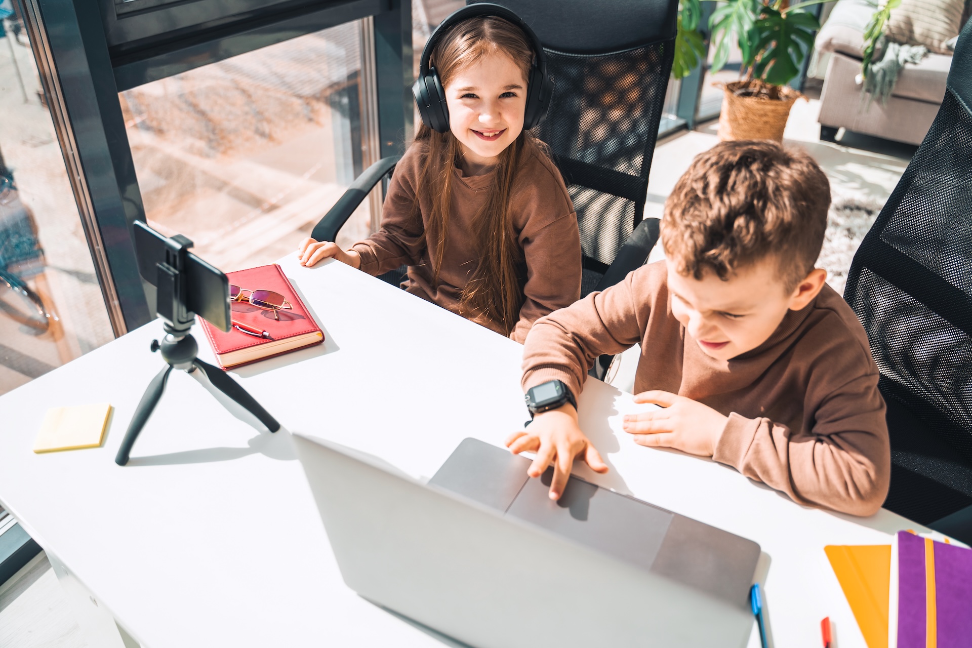 Kinder beim Streamen am Laptop und Handy – Lernen und Spaß haben. Kinder beim Streamen am Laptop und Handy – Lernen und Spaß haben.